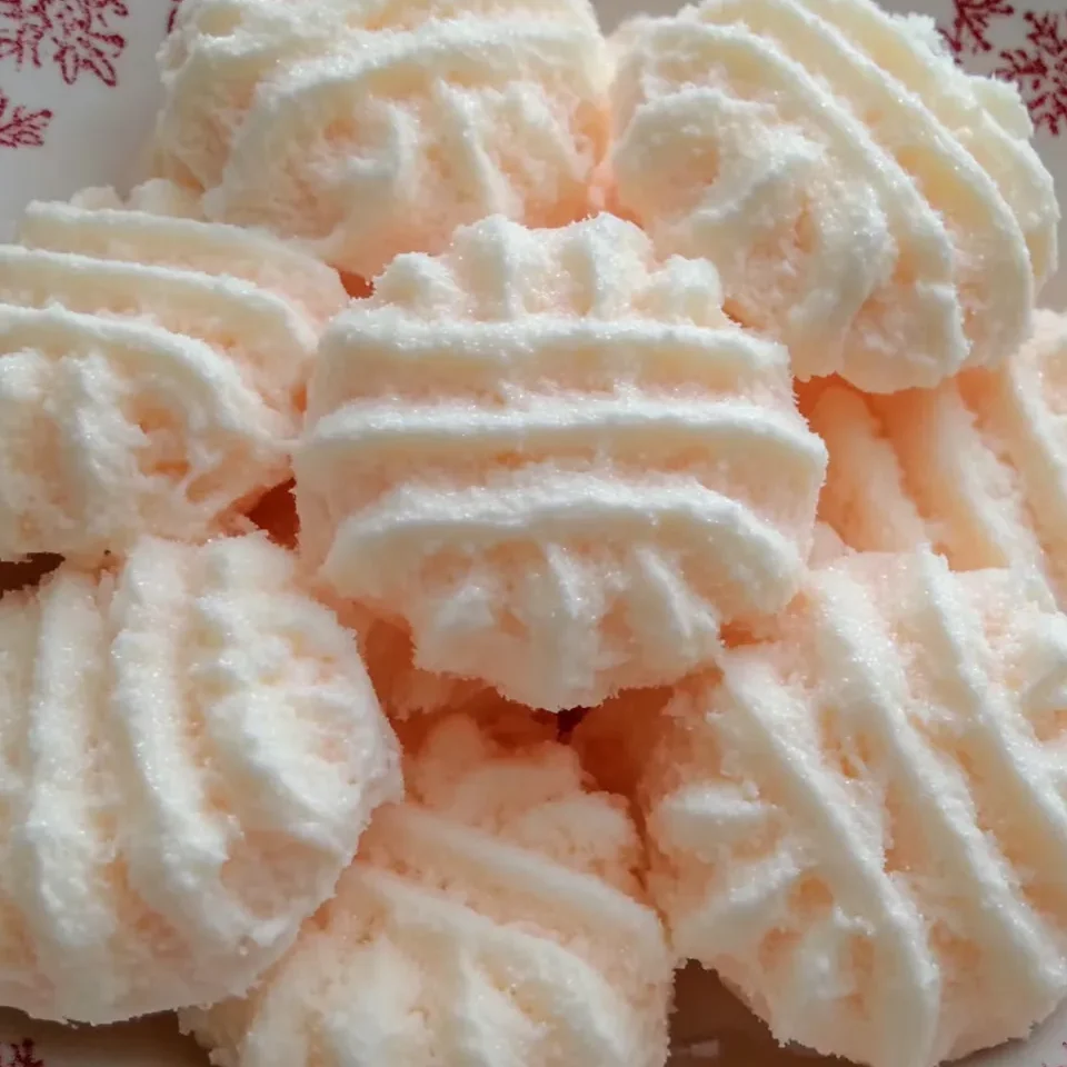 Bowl of assorted cream cheese mints in pink, green, and white pastel shades.