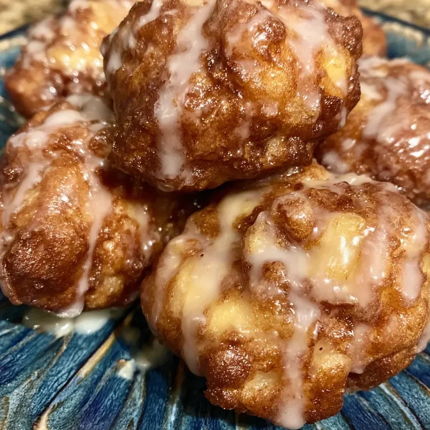 Close-up of fritter bite showing chunks of juicy apple and light glaze.
