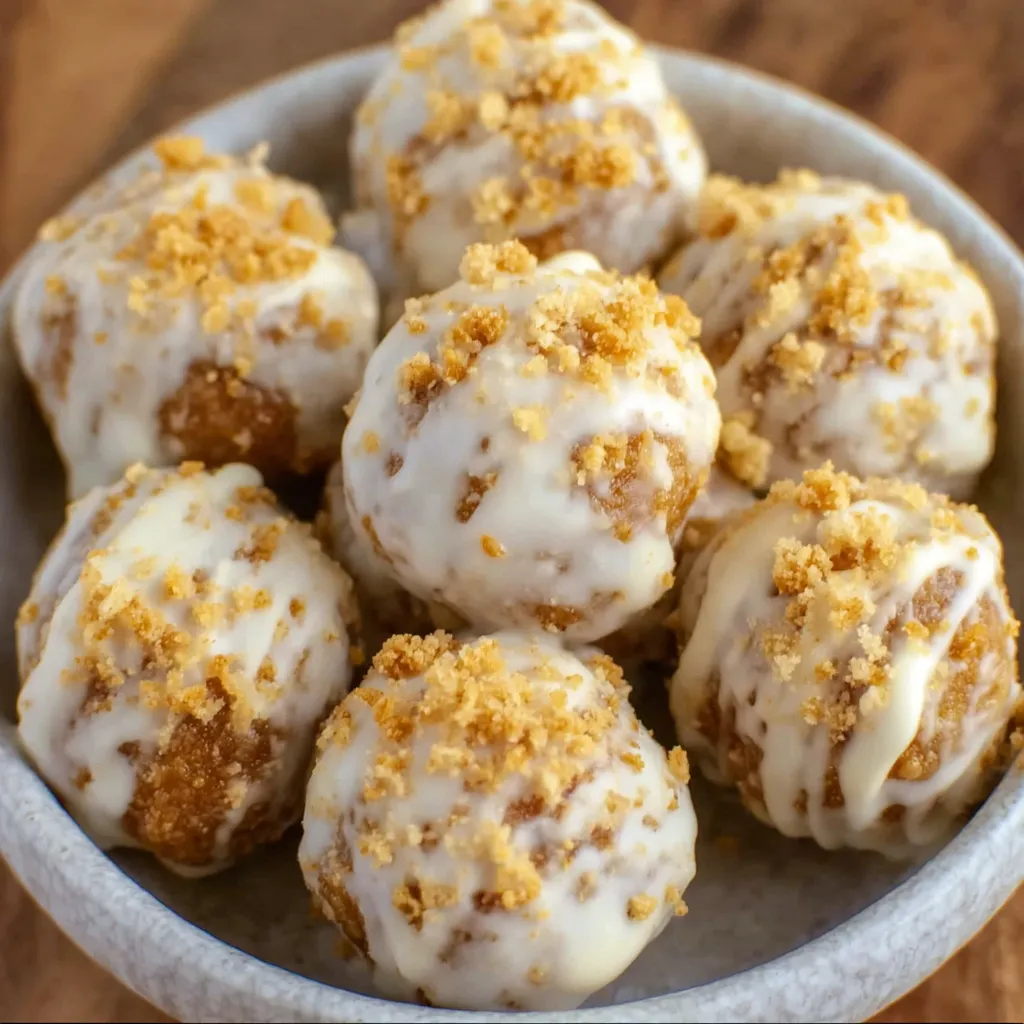 Tray of no-bake pumpkin pie balls arranged with cinnamon sticks and pumpkins.