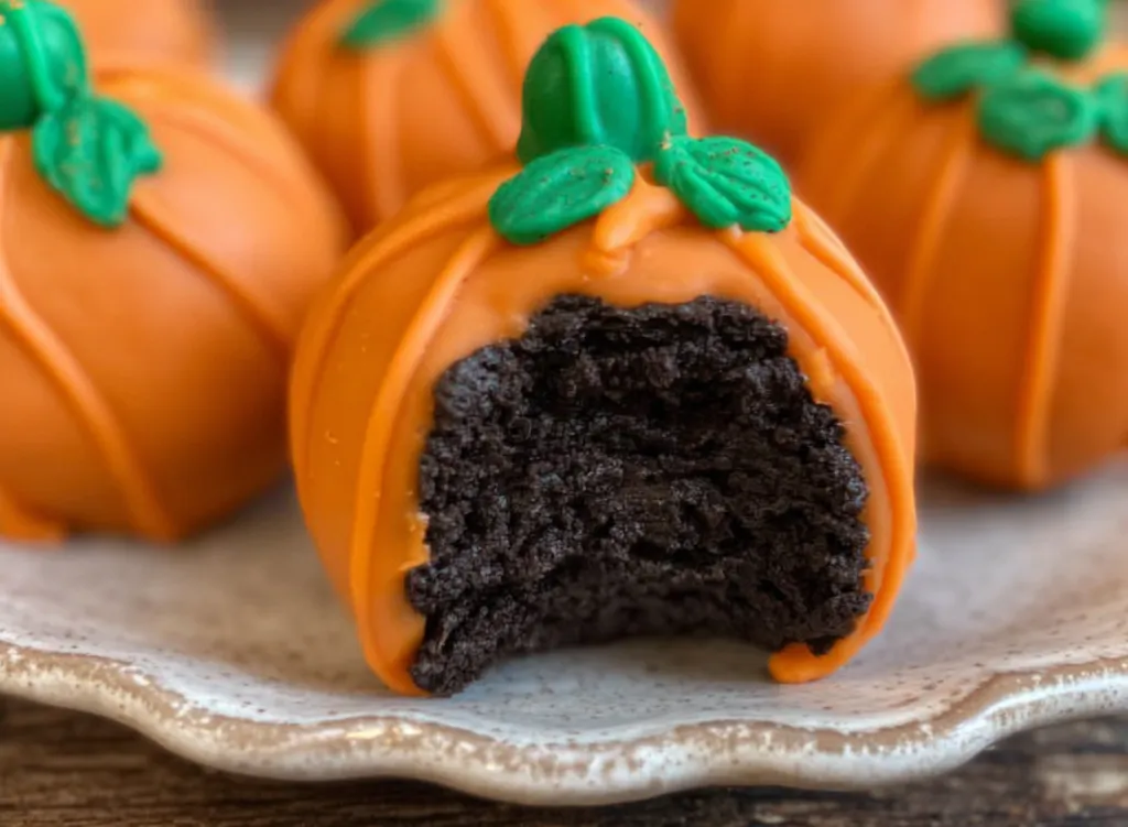 Close-up of Oreo ball showing creamy chocolate filling inside orange shell.